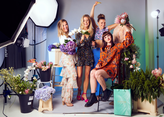 fire damer med blomster rundt seg og de selv i blomstrete kjoler