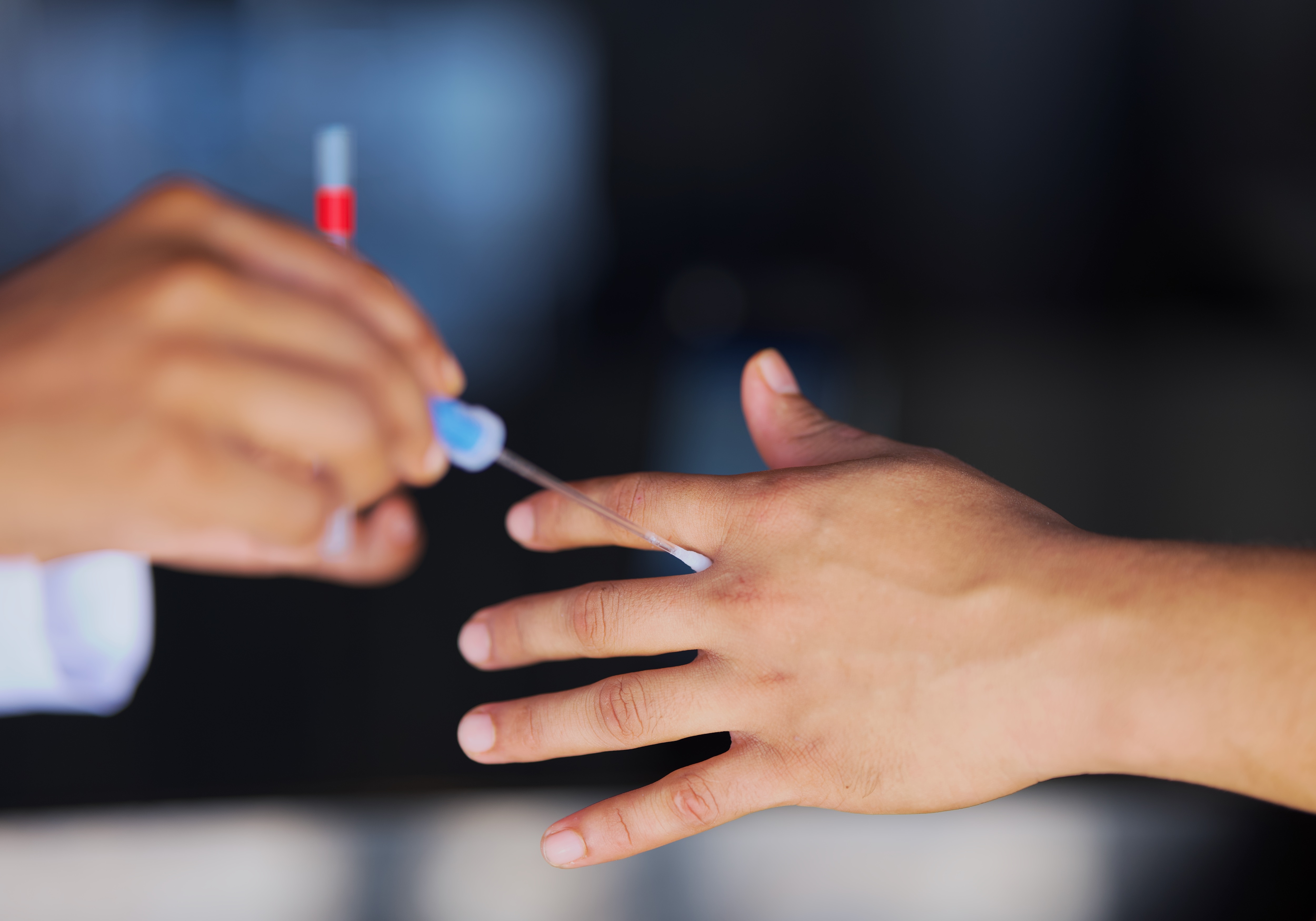 Staff member taking swab of team member hand