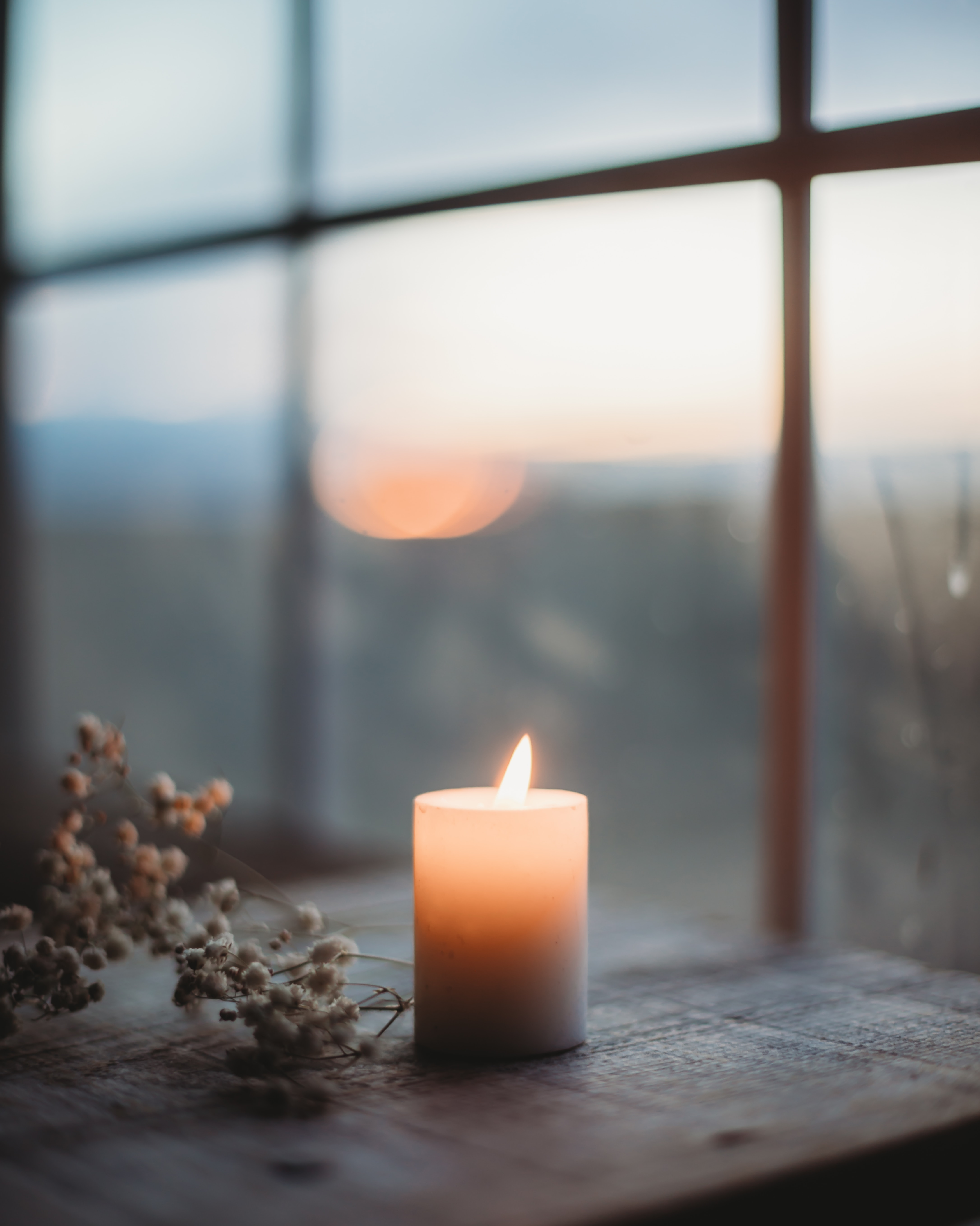 Lit candle by a window