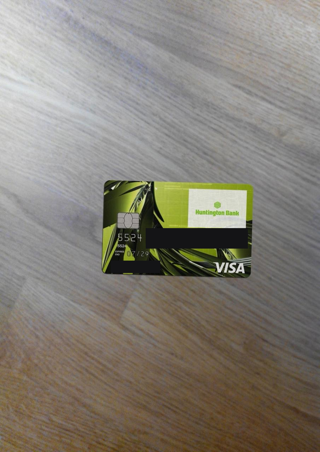 Front of a fraudulent credit card showing Visa branding on an account number beginning with 5, with the digits and cardholder name redacted