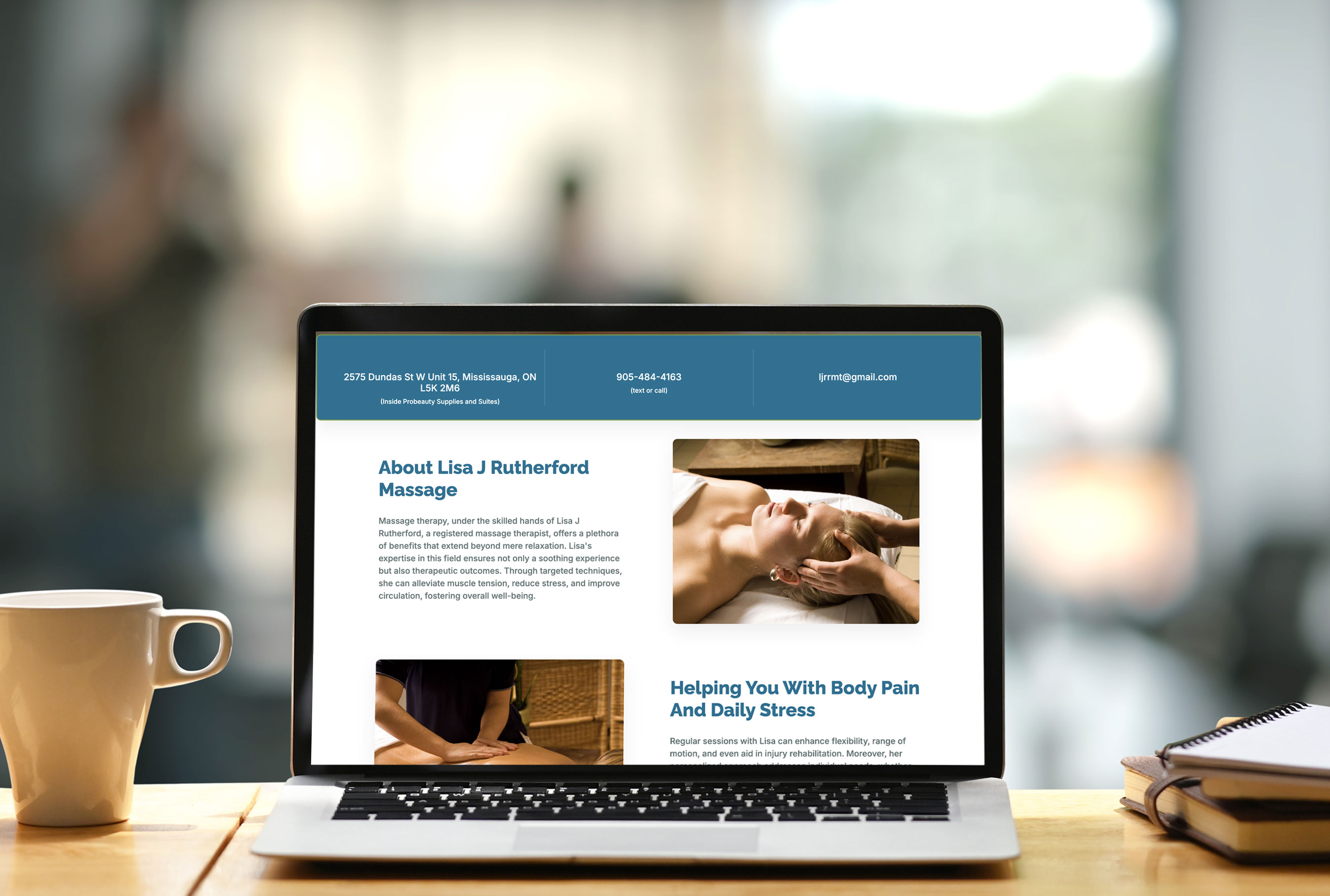 Laptop displaying the 'About' page of Lisa J Rutherford Massage website. The screen shows location and contact information at the top, followed by sections detailing Lisa’s massage therapy services and benefits. Images of a woman receiving a head massage and a therapist’s hands in action accompany the text. A coffee cup and notebook are visible on the wooden table in front of the laptop.