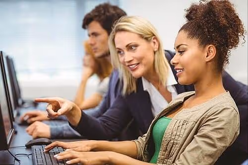 Business school professor pointing to a student's computer screen