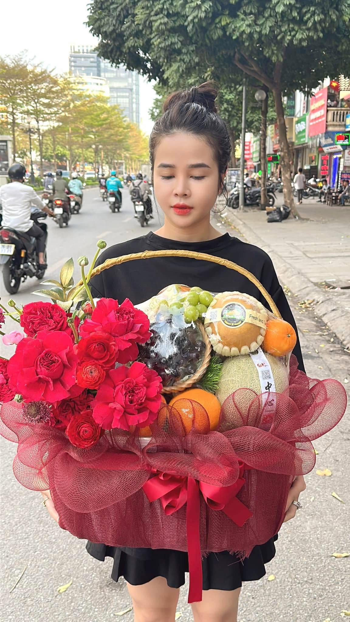 Cô gái cầm giỏ trái cây đỏ trên phố tại Huyện Nam Đàn, Nghệ An
