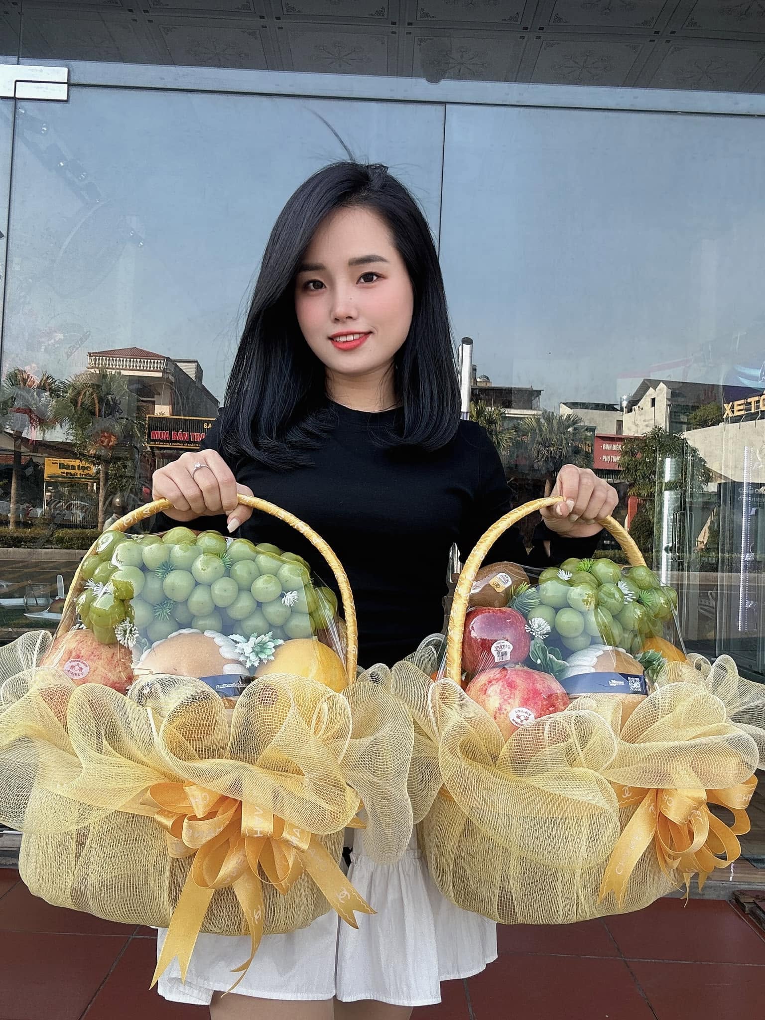 Cô gái cầm hai giỏ trái cây bọc lưới vàng tại Huyện Cư Jút, Đăk Nông