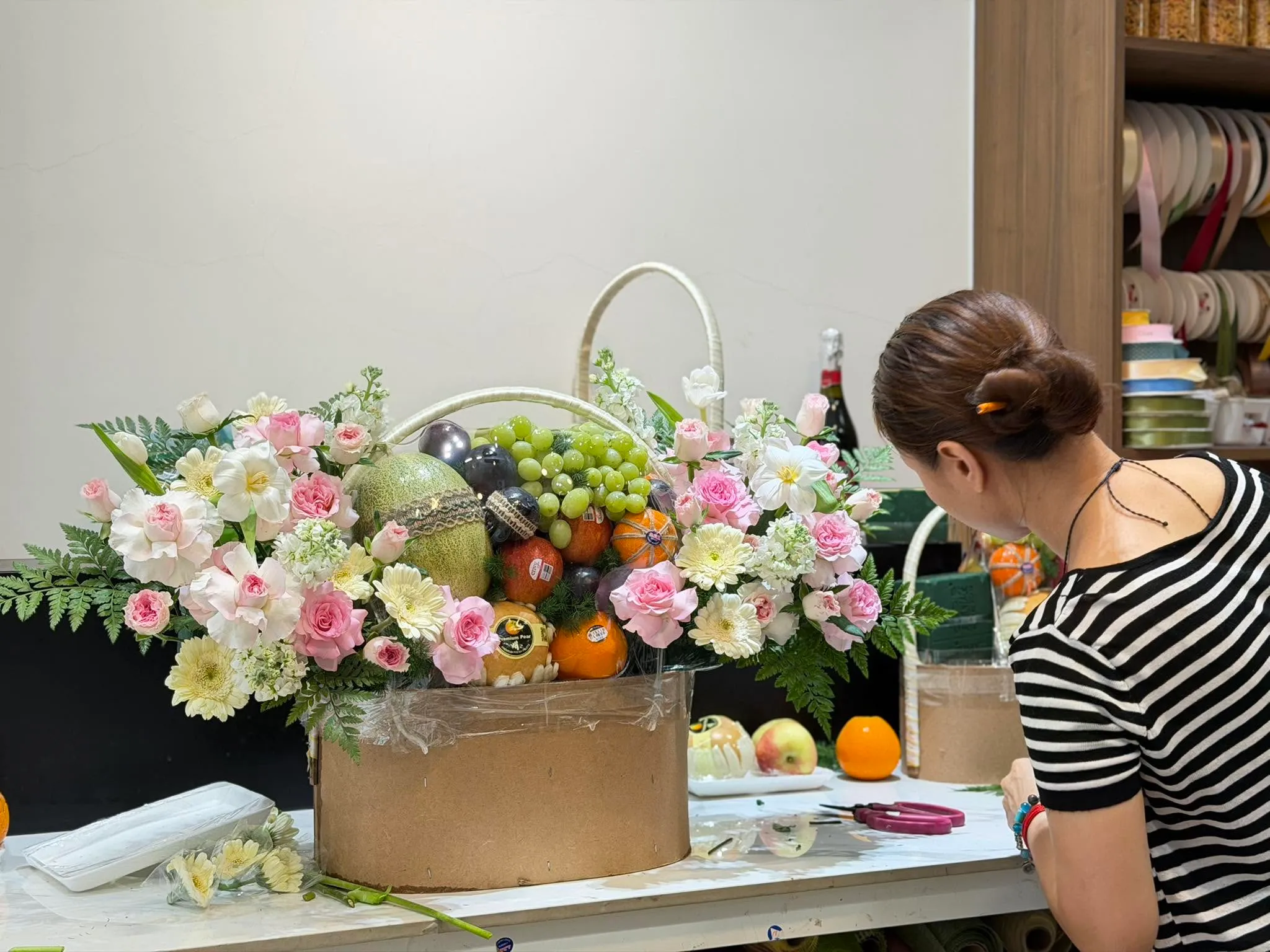 Nhân viên cắt tỉa giỏ hoa phối trái cây hồng trắng tại Huyện Côn Đảo