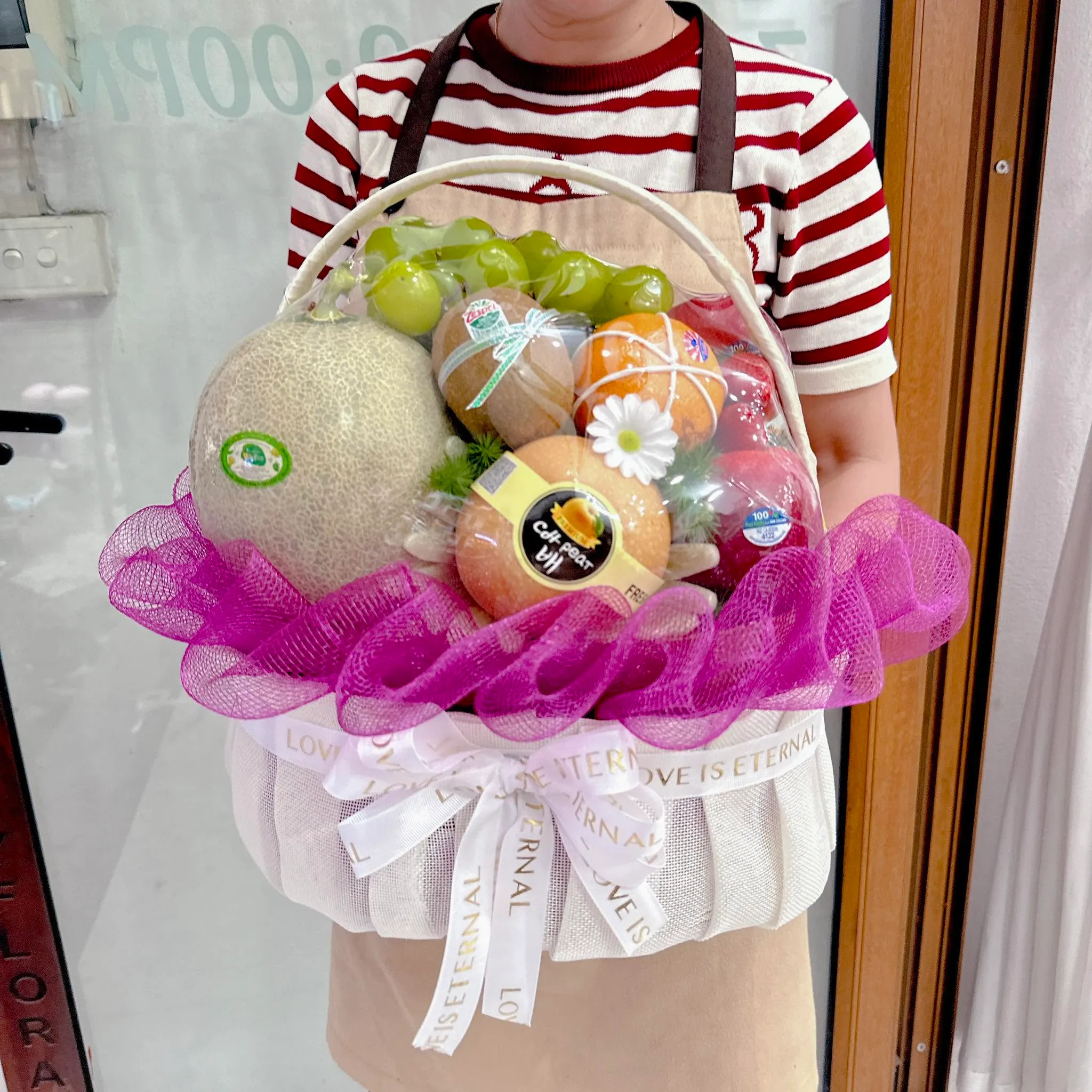 Người cầm giỏ trái cây dưa lưới nho phối lưới hồng tại Huyện Tam Đường, Lai Châu