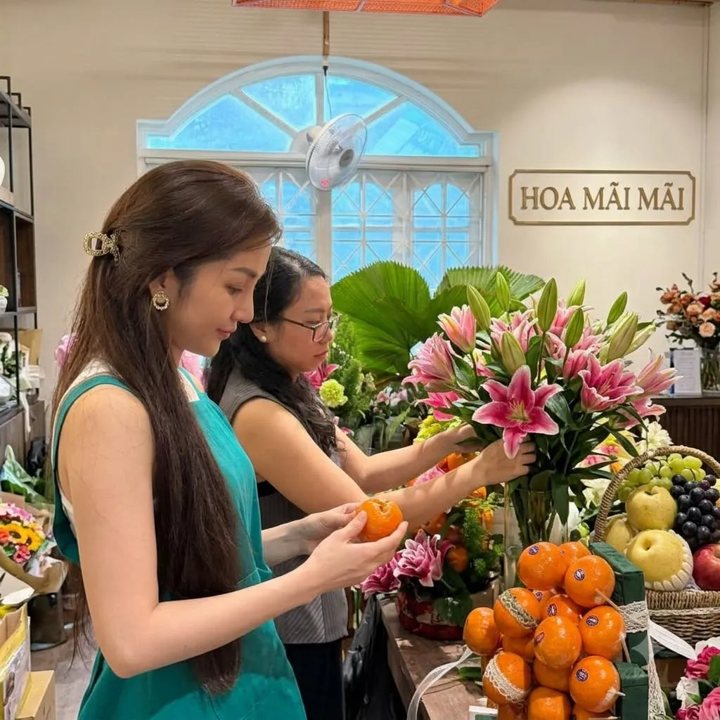 Nhân viên cắm hoa ly hồng bên khay cam trang trí nơ tại Châu Thành, Long An