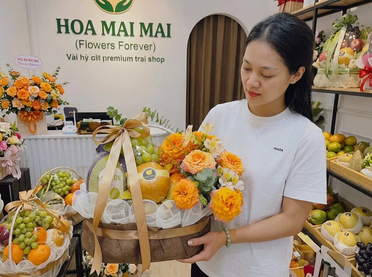 Nhân viên áo trắng bưng giỏ hoa cam phối trái cây trước cửa tại Huyện Long Điền, Bà Rịa Vũng Tàu