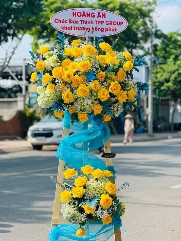 Màu sắc: vàng tươi sáng. Dịp tặng: khai trương, khánh thành, tân gia, chúc mừng thành công, kỷ niệm thành lập. Loại sản phẩm: Hoa khai trương.

Hoa Mừng Lễ Khởi Công - HKT.02 là mẫu kệ hoa khai trương mang tone màu chủ đạo vàng tươi sáng, tượng trưng cho phú quý, thịnh vượng và phát tài phát lộc — lựa chọn được nhiều khách hàng tin tưởng khi cần một lẵng hoa khai trương thật ấn tượng.

Thành phần hoa chính gồm hồng vàng, lay ơn vàng và cúc mâm xôi vàng, phối cùng dương xỉ, lá bạc và baby trắng để tôn lên tổng thể tươi tắn, hài hòa và tràn đầy sức sống cho không gian khai trương.

Sản phẩm được thiết kế theo dáng kệ hoa đứng 1 tầng nhỏ gọn, form dáng vững chãi, cân đối, phù hợp trưng bày ở những vị trí trang trọng, dễ gây ấn tượng ngay từ cái nhìn đầu tiên.

Chiều cao kệ hoa khoảng 1m6 – 1m8 tùy mẫu, đường kính chân đế 50 – 60cm, kích thước lý tưởng để đặt trước sảnh, cửa ra vào hoặc khu vực sự kiện mà không chiếm quá nhiều diện tích.

Đây là món quà thích hợp gửi tặng trong các dịp khai trương cửa hàng, công ty, spa, khách sạn, nhà hàng, văn phòng hay showroom, giúp chủ nhân buổi lễ thêm phần rạng rỡ và trang trọng.

Với thiết kế sang trọng, Hoa Mừng Lễ Khởi Công - HKT.02 là mẫu kệ hoa khai trương, lẵng hoa khai trương được yêu thích trong nhóm hoa khai trương sang trọng, hoa khai trương cao cấp dành cho khách hàng doanh nghiệp.

Sản phẩm gửi gắm thông điệp chúc mừng ý nghĩa: chúc công việc kinh doanh thuận buồm xuôi gió, làm ăn phát đạt, vạn sự hanh thông và ngày càng thịnh vượng. Dải băng rôn có thể tùy chỉnh nội dung lời chúc theo yêu cầu.

Liên hệ Shop Hoa Mãi Mãi ngay hôm nay để được tư vấn chọn mẫu phù hợp và đặt hoa giao nhanh tận nơi!
