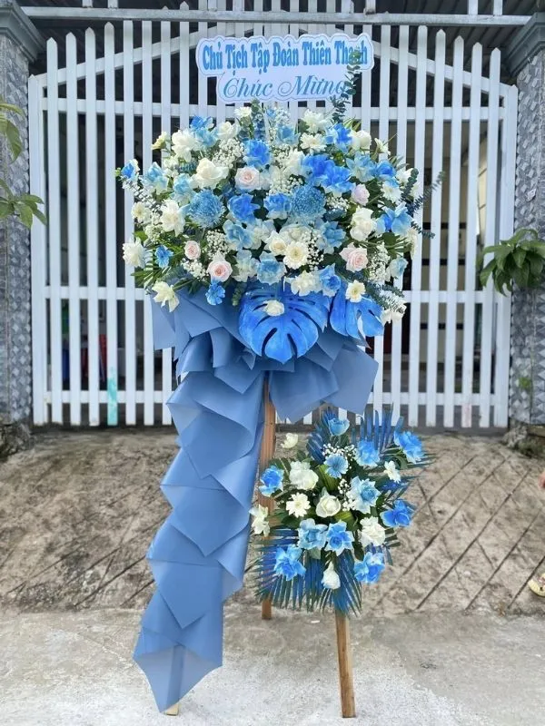 Màu sắc: xanh lá - xanh ngọc dịu mắt. Dịp tặng: khai trương, khánh thành, tân gia, chúc mừng thành công, kỷ niệm thành lập. Loại sản phẩm: Hoa khai trương.

Kệ Hoa Khai Trương - HKT 679 là mẫu kệ hoa khai trương mang tone màu chủ đạo xanh lá - xanh ngọc dịu mắt, tượng trưng cho sự sinh sôi, phát triển bền vững và tươi mới tràn đầy sức sống — lựa chọn được nhiều khách hàng tin tưởng khi cần một lẵng hoa khai trương thật ấn tượng.

Thành phần hoa chính gồm hồng xanh ngọc, lys trắng và cúc xanh, phối cùng dương xỉ, lá bạc và baby trắng để tôn lên tổng thể tươi tắn, hài hòa và tràn đầy sức sống cho không gian khai trương.

Sản phẩm được thiết kế theo dáng kệ hoa đứng 1 tầng nhỏ gọn, form dáng vững chãi, cân đối, phù hợp trưng bày ở những vị trí trang trọng, dễ gây ấn tượng ngay từ cái nhìn đầu tiên.

Chiều cao kệ hoa khoảng 1m6 – 1m8 tùy mẫu, đường kính chân đế 50 – 60cm, kích thước lý tưởng để đặt trước sảnh, cửa ra vào hoặc khu vực sự kiện mà không chiếm quá nhiều diện tích.

Đây là món quà thích hợp gửi tặng trong các dịp khai trương cửa hàng, công ty, spa, khách sạn, nhà hàng, văn phòng hay showroom, giúp chủ nhân buổi lễ thêm phần rạng rỡ và trang trọng.

Với thiết kế sang trọng, Kệ Hoa Khai Trương - HKT 679 là mẫu kệ hoa khai trương, lẵng hoa khai trương được yêu thích trong nhóm hoa khai trương sang trọng, hoa khai trương cao cấp dành cho khách hàng doanh nghiệp.

Sản phẩm gửi gắm thông điệp chúc mừng ý nghĩa: chúc công việc kinh doanh thuận buồm xuôi gió, làm ăn phát đạt, vạn sự hanh thông và ngày càng thịnh vượng. Dải băng rôn có thể tùy chỉnh nội dung lời chúc theo yêu cầu.

Liên hệ Shop Hoa Mãi Mãi ngay hôm nay để được tư vấn chọn mẫu phù hợp và đặt hoa giao nhanh tận nơi!