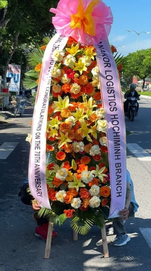 Màu sắc: xanh lá - xanh ngọc dịu mắt. Dịp tặng: khai trương, khánh thành, tân gia, chúc mừng thành công, kỷ niệm thành lập. Loại sản phẩm: Hoa khai trương.

Hoa Khai Trương Hàn Quốc 333 là mẫu kệ hoa khai trương mang tone màu chủ đạo xanh lá - xanh ngọc dịu mắt, tượng trưng cho sự sinh sôi, phát triển bền vững và tươi mới tràn đầy sức sống — lựa chọn được nhiều khách hàng tin tưởng khi cần một lẵng hoa khai trương thật ấn tượng.

Thành phần hoa chính gồm lan hồ điệp xanh ngọc, cúc xanh và cẩm tú cầu xanh, phối cùng lá tràng pháo, lá cau cảnh và lá thiên tuế để tôn lên tổng thể tươi tắn, hài hòa và tràn đầy sức sống cho không gian khai trương.

Sản phẩm được thiết kế theo dáng kệ hoa đứng 1 tầng nhỏ gọn, form dáng vững chãi, cân đối, phù hợp trưng bày ở những vị trí trang trọng, dễ gây ấn tượng ngay từ cái nhìn đầu tiên.

Chiều cao kệ hoa khoảng 1m6 – 1m8 tùy mẫu, đường kính chân đế 50 – 60cm, kích thước lý tưởng để đặt trước sảnh, cửa ra vào hoặc khu vực sự kiện mà không chiếm quá nhiều diện tích.

Đây là món quà thích hợp gửi tặng trong các dịp khai trương cửa hàng, công ty, spa, khách sạn, nhà hàng, văn phòng hay showroom, giúp chủ nhân buổi lễ thêm phần rạng rỡ và trang trọng.

Với thiết kế sang trọng, Hoa Khai Trương Hàn Quốc 333 là mẫu kệ hoa khai trương, lẵng hoa khai trương được yêu thích trong nhóm hoa khai trương sang trọng, hoa khai trương cao cấp dành cho khách hàng doanh nghiệp.

Sản phẩm gửi gắm thông điệp chúc mừng ý nghĩa: chúc công việc kinh doanh thuận buồm xuôi gió, làm ăn phát đạt, vạn sự hanh thông và ngày càng thịnh vượng. Dải băng rôn có thể tùy chỉnh nội dung lời chúc theo yêu cầu.

Liên hệ Shop Hoa Mãi Mãi ngay hôm nay để được tư vấn chọn mẫu phù hợp và đặt hoa giao nhanh tận nơi!
