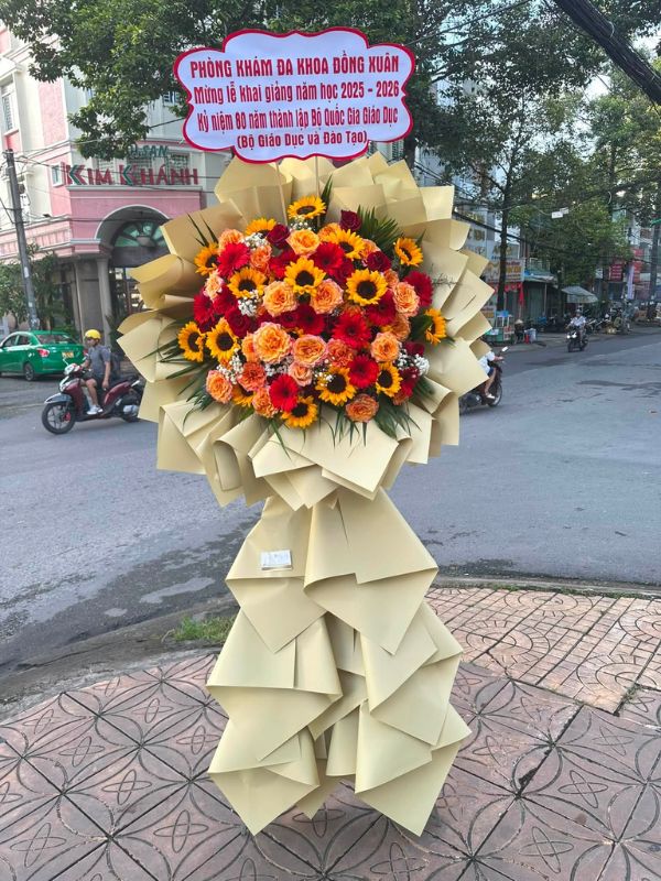 Màu sắc: hồng cam pastel nhẹ nhàng. Dịp tặng: khai trương, khánh thành, tân gia, chúc mừng thành công, kỷ niệm thành lập. Loại sản phẩm: Hoa khai trương.

Kệ Hoa Khai Trương 1 Tầng - HKT 115 là mẫu kệ hoa khai trương mang tone màu chủ đạo hồng cam pastel nhẹ nhàng, tượng trưng cho sự tươi mới, hài hòa và may mắn nhẹ nhàng, tinh tế — lựa chọn được nhiều khách hàng tin tưởng khi cần một lẵng hoa khai trương thật ấn tượng.

Thành phần hoa chính gồm hồng cam pastel, cát tường hồng và baby trắng, phối cùng dương xỉ, lá bạc và baby trắng để tôn lên tổng thể tươi tắn, hài hòa và tràn đầy sức sống cho không gian khai trương.

Sản phẩm được thiết kế theo dáng kệ hoa đứng 1 tầng nhỏ gọn, form dáng vững chãi, cân đối, phù hợp trưng bày ở những vị trí trang trọng, dễ gây ấn tượng ngay từ cái nhìn đầu tiên.

Chiều cao kệ hoa khoảng 1m6 – 1m8 tùy mẫu, đường kính chân đế 50 – 60cm, kích thước lý tưởng để đặt trước sảnh, cửa ra vào hoặc khu vực sự kiện mà không chiếm quá nhiều diện tích.

Đây là món quà thích hợp gửi tặng trong các dịp khai trương cửa hàng, công ty, spa, khách sạn, nhà hàng, văn phòng hay showroom, giúp chủ nhân buổi lễ thêm phần rạng rỡ và trang trọng.

Với thiết kế sang trọng, Kệ Hoa Khai Trương 1 Tầng - HKT 115 là mẫu kệ hoa khai trương, lẵng hoa khai trương được yêu thích trong nhóm hoa khai trương sang trọng, hoa khai trương cao cấp dành cho khách hàng doanh nghiệp.

Sản phẩm gửi gắm thông điệp chúc mừng ý nghĩa: chúc công việc kinh doanh thuận buồm xuôi gió, làm ăn phát đạt, vạn sự hanh thông và ngày càng thịnh vượng. Dải băng rôn có thể tùy chỉnh nội dung lời chúc theo yêu cầu.

Liên hệ Shop Hoa Mãi Mãi ngay hôm nay để được tư vấn chọn mẫu phù hợp và đặt hoa giao nhanh tận nơi!