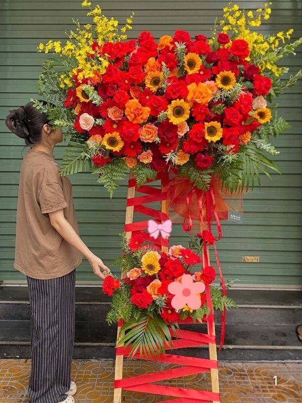 Màu sắc: đỏ tươi rực rỡ. Dịp tặng: khai trương, khánh thành, tân gia, chúc mừng thành công, kỷ niệm thành lập. Loại sản phẩm: Hoa khai trương.

Lẵng Hoa Khai Trương Nhập Khẩu - HKT 79 là mẫu kệ hoa khai trương mang tone màu chủ đạo đỏ tươi rực rỡ, tượng trưng cho may mắn, thành công rực rỡ và tài lộc dồi dào — lựa chọn được nhiều khách hàng tin tưởng khi cần một lẵng hoa khai trương thật ấn tượng.

Thành phần hoa chính gồm hồng đỏ, cẩm chướng đỏ và lys đỏ, phối cùng lá cau cảnh, baby trắng và lá thiên tuế để tôn lên tổng thể tươi tắn, hài hòa và tràn đầy sức sống cho không gian khai trương.

Sản phẩm được thiết kế theo dáng kệ hoa đứng 2 tầng cân đối, form dáng vững chãi, cân đối, phù hợp trưng bày ở những vị trí trang trọng, dễ gây ấn tượng ngay từ cái nhìn đầu tiên.

Chiều cao kệ hoa khoảng 1m7 – 1m9 tùy mẫu, đường kính chân đế 55 – 65cm, kích thước lý tưởng để đặt trước sảnh, cửa ra vào hoặc khu vực sự kiện mà không chiếm quá nhiều diện tích.

Đây là món quà thích hợp gửi tặng trong các dịp khai trương cửa hàng, công ty, spa, khách sạn, nhà hàng, văn phòng hay showroom, giúp chủ nhân buổi lễ thêm phần rạng rỡ và trang trọng.

Với thiết kế sang trọng, Lẵng Hoa Khai Trương Nhập Khẩu - HKT 79 là mẫu kệ hoa khai trương, lẵng hoa khai trương được yêu thích trong nhóm hoa khai trương sang trọng, hoa khai trương cao cấp dành cho khách hàng doanh nghiệp.

Sản phẩm gửi gắm thông điệp chúc mừng ý nghĩa: chúc công việc kinh doanh thuận buồm xuôi gió, làm ăn phát đạt, vạn sự hanh thông và ngày càng thịnh vượng. Dải băng rôn có thể tùy chỉnh nội dung lời chúc theo yêu cầu.

Liên hệ Shop Hoa Mãi Mãi ngay hôm nay để được tư vấn chọn mẫu phù hợp và đặt hoa giao nhanh tận nơi!