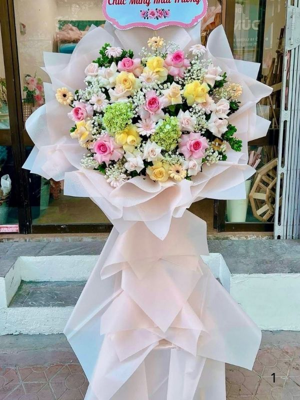 Màu sắc: đỏ tươi rực rỡ. Dịp tặng: khai trương, khánh thành, tân gia, chúc mừng thành công, kỷ niệm thành lập. Loại sản phẩm: Hoa khai trương.

Hoa Chúc Mừng - HKT 779 là mẫu kệ hoa khai trương mang tone màu chủ đạo đỏ tươi rực rỡ, tượng trưng cho may mắn, thành công rực rỡ và tài lộc dồi dào — lựa chọn được nhiều khách hàng tin tưởng khi cần một lẵng hoa khai trương thật ấn tượng.

Thành phần hoa chính gồm hồng đỏ, cẩm chướng đỏ và lys đỏ, phối cùng lá cau cảnh, baby trắng và lá thiên tuế để tôn lên tổng thể tươi tắn, hài hòa và tràn đầy sức sống cho không gian khai trương.

Sản phẩm được thiết kế theo dáng kệ hoa đứng 1 tầng nhỏ gọn, form dáng vững chãi, cân đối, phù hợp trưng bày ở những vị trí trang trọng, dễ gây ấn tượng ngay từ cái nhìn đầu tiên.

Chiều cao kệ hoa khoảng 1m6 – 1m8 tùy mẫu, đường kính chân đế 50 – 60cm, kích thước lý tưởng để đặt trước sảnh, cửa ra vào hoặc khu vực sự kiện mà không chiếm quá nhiều diện tích.

Đây là món quà thích hợp gửi tặng trong các dịp khai trương cửa hàng, công ty, spa, khách sạn, nhà hàng, văn phòng hay showroom, giúp chủ nhân buổi lễ thêm phần rạng rỡ và trang trọng.

Với thiết kế sang trọng, Hoa Chúc Mừng - HKT 779 là mẫu kệ hoa khai trương, lẵng hoa khai trương được yêu thích trong nhóm hoa khai trương sang trọng, hoa khai trương cao cấp dành cho khách hàng doanh nghiệp.

Sản phẩm gửi gắm thông điệp chúc mừng ý nghĩa: chúc công việc kinh doanh thuận buồm xuôi gió, làm ăn phát đạt, vạn sự hanh thông và ngày càng thịnh vượng. Dải băng rôn có thể tùy chỉnh nội dung lời chúc theo yêu cầu.

Liên hệ Shop Hoa Mãi Mãi ngay hôm nay để được tư vấn chọn mẫu phù hợp và đặt hoa giao nhanh tận nơi!