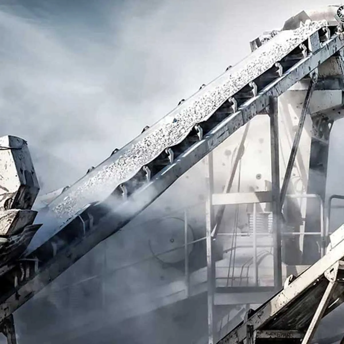 Conveyor belt transporting crushed stone in a dusty industrial quarry setting.