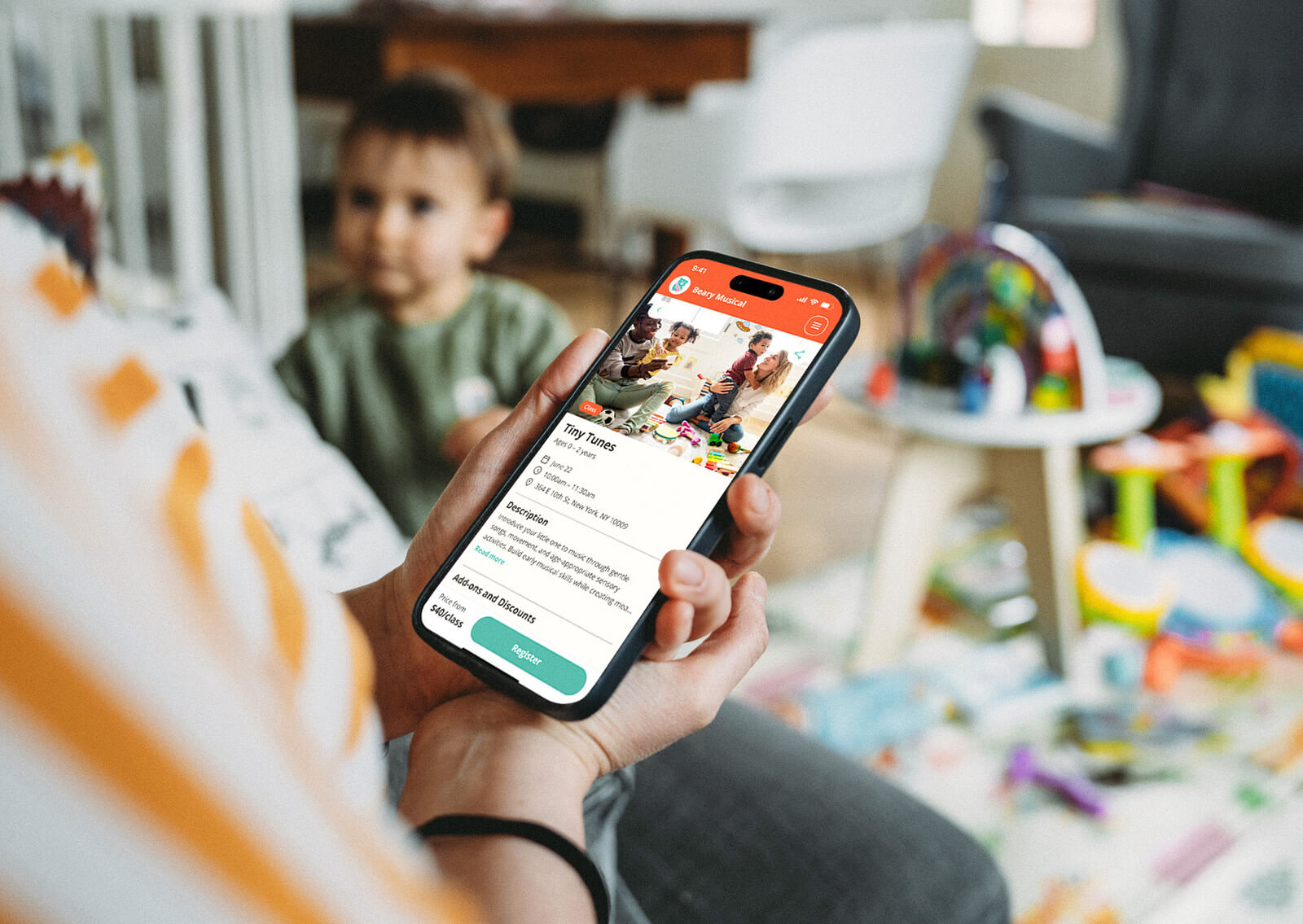 Parent looking at a custom branded app while looking after their child playing in their living room. 