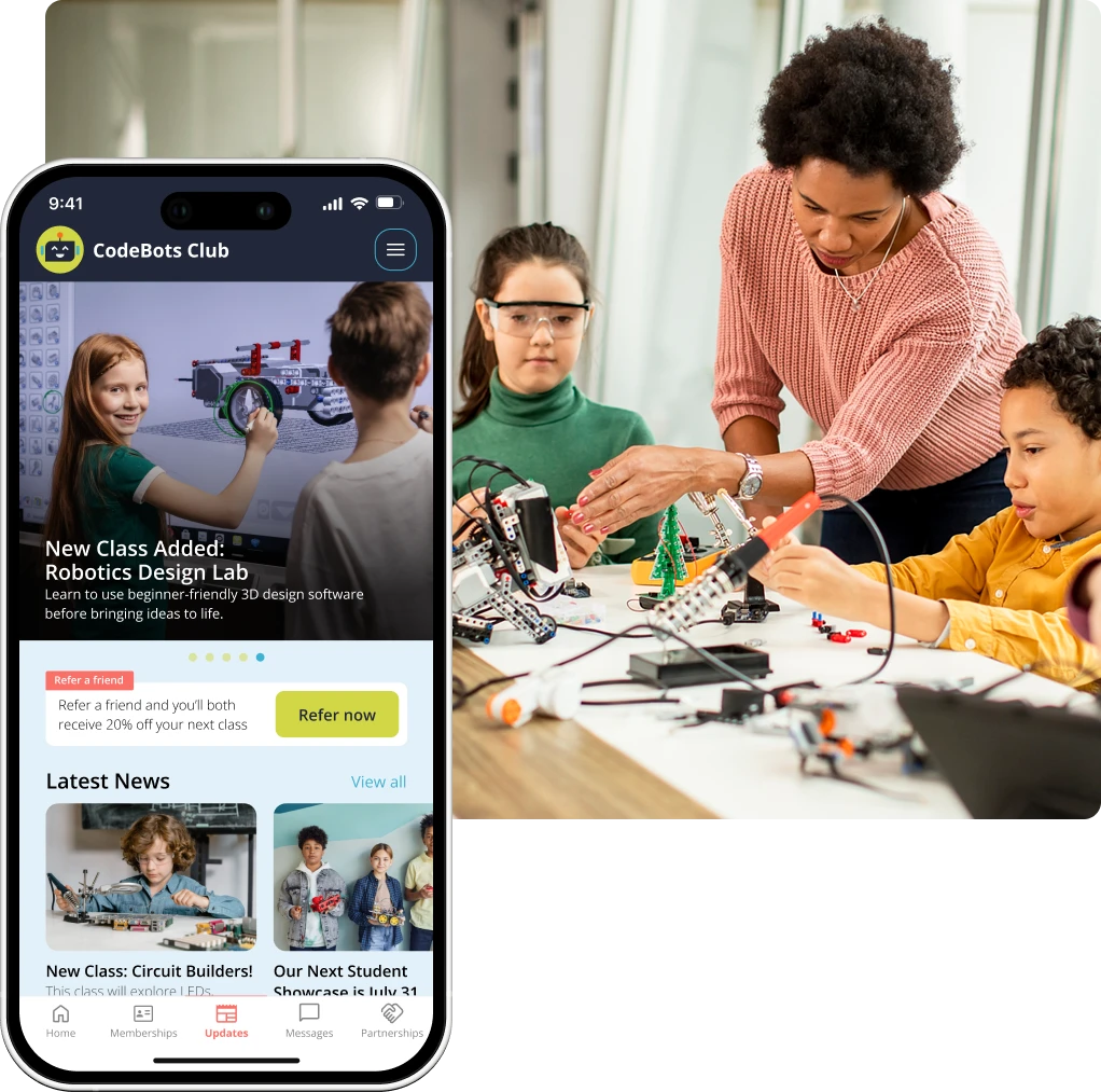 Image of robotics instructor with a group of students in class with custom branded app screen showing updates and news