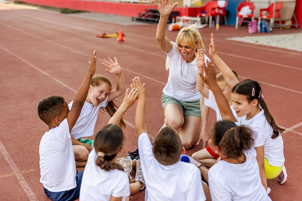 Track coach celebrating with her team