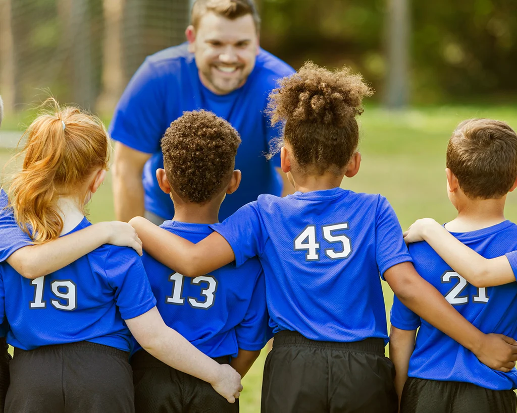 Coach smiling at soccer team lineup