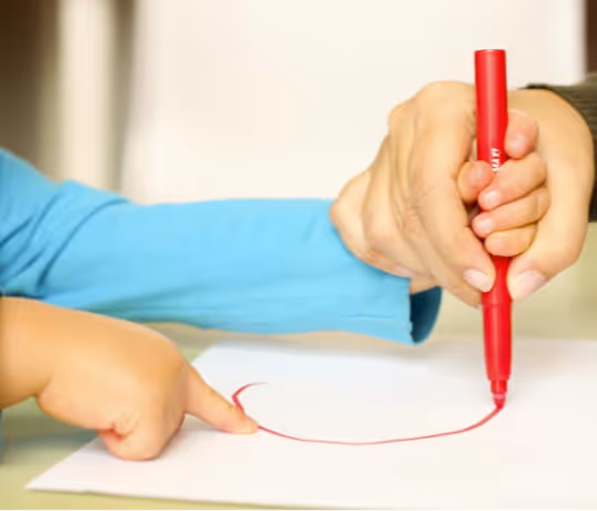 niño dibujando con rotulador rojo