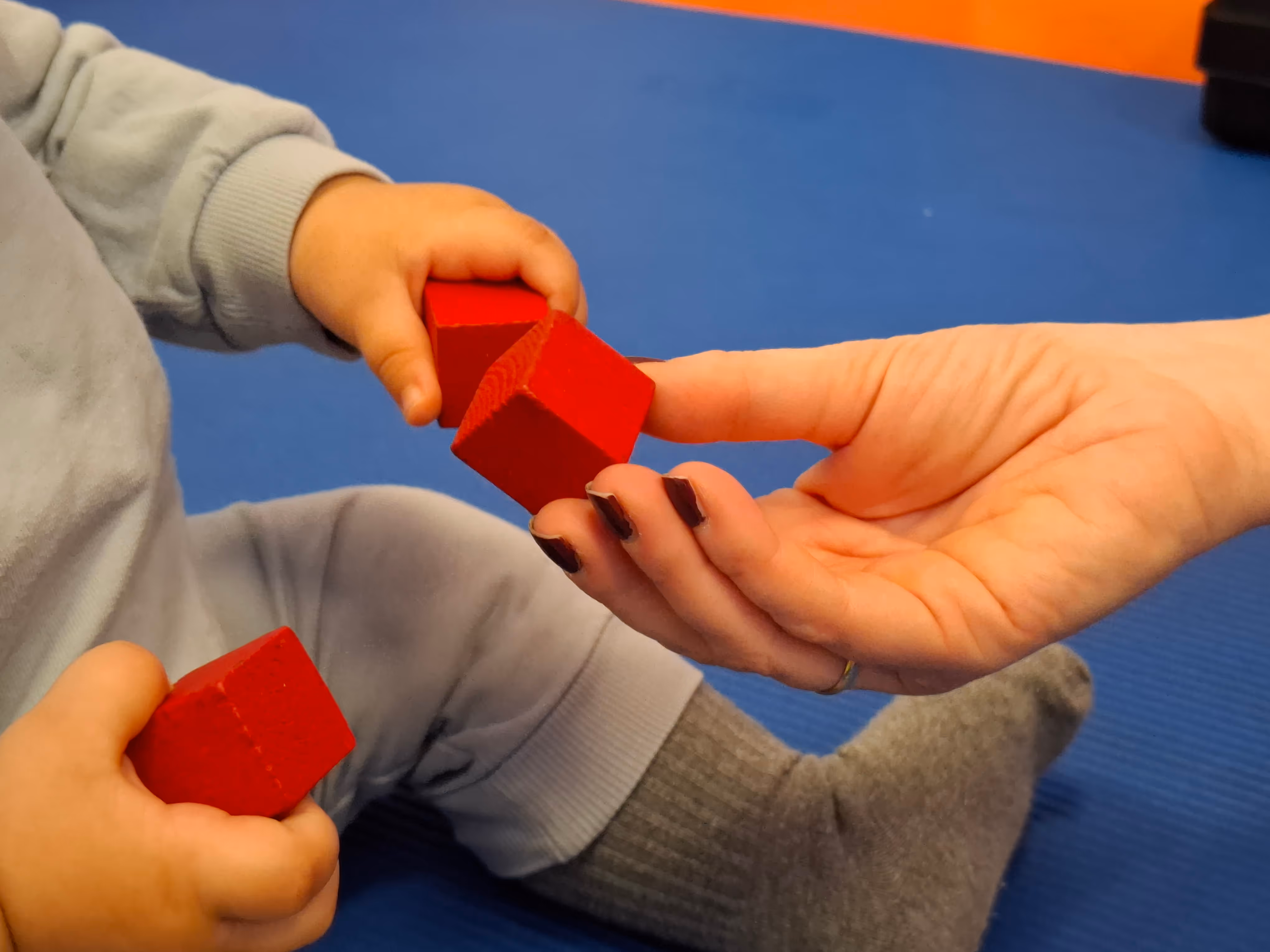 bebe jugando con bloques rojos