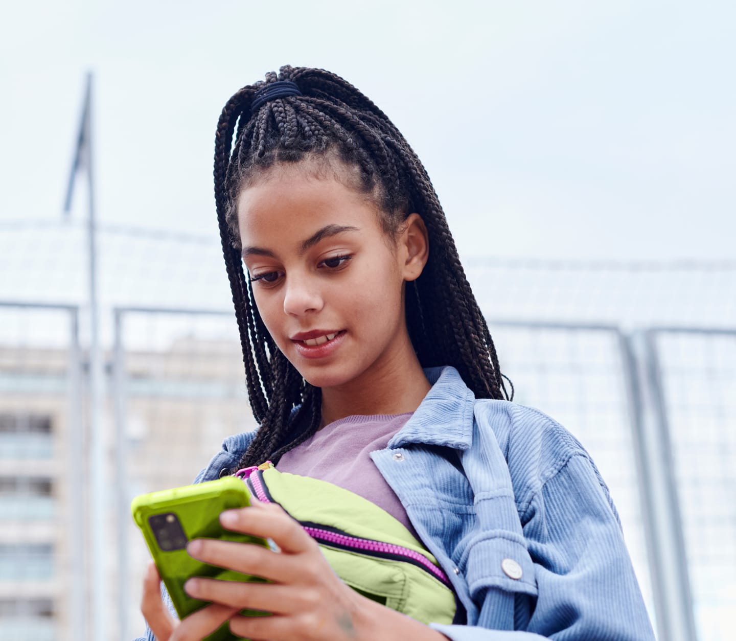 Teenage girl with braids looking at her phone