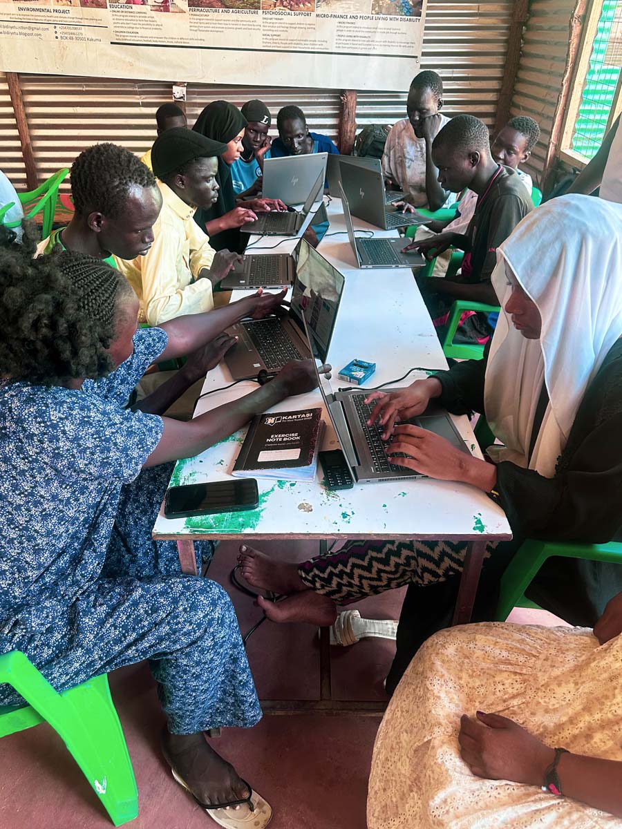 A group gathered around the laptops
