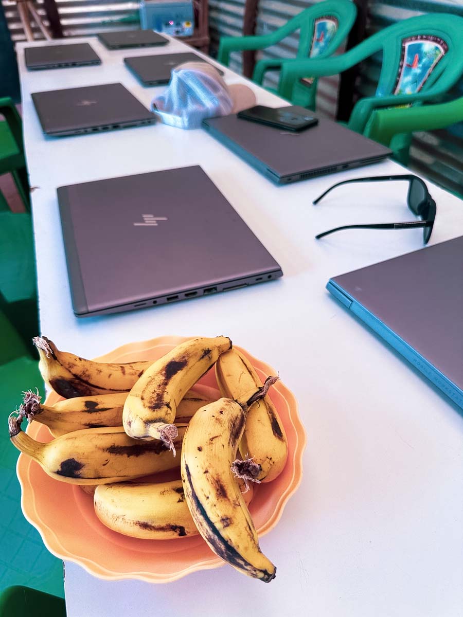 Laptops on a table beside a plate of bananas