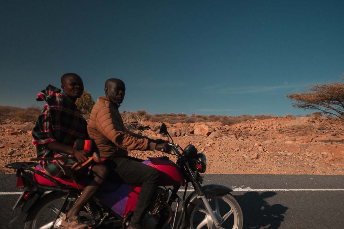 Two riders on a motorbike in Kakuma