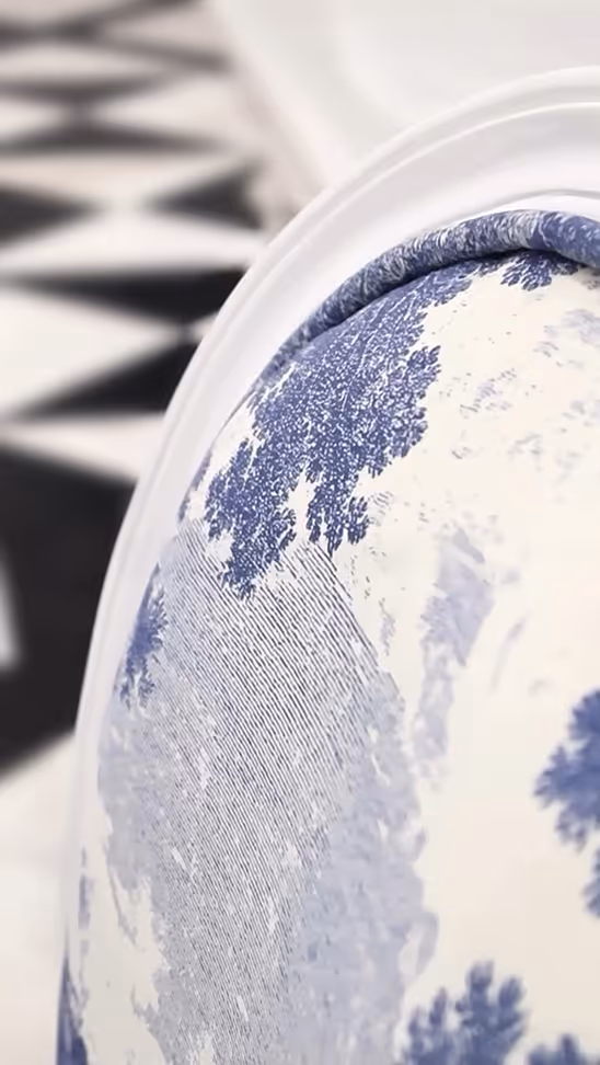 Detail view of illustrated chair fabric designed by KRT Design Studio, showcasing a blue-and-white scenic toile pattern on upholstered furniture with refined texture and edge detailing, reflecting craftsmanship-led illustration, material sensitivity, and timeless luxury interior design.