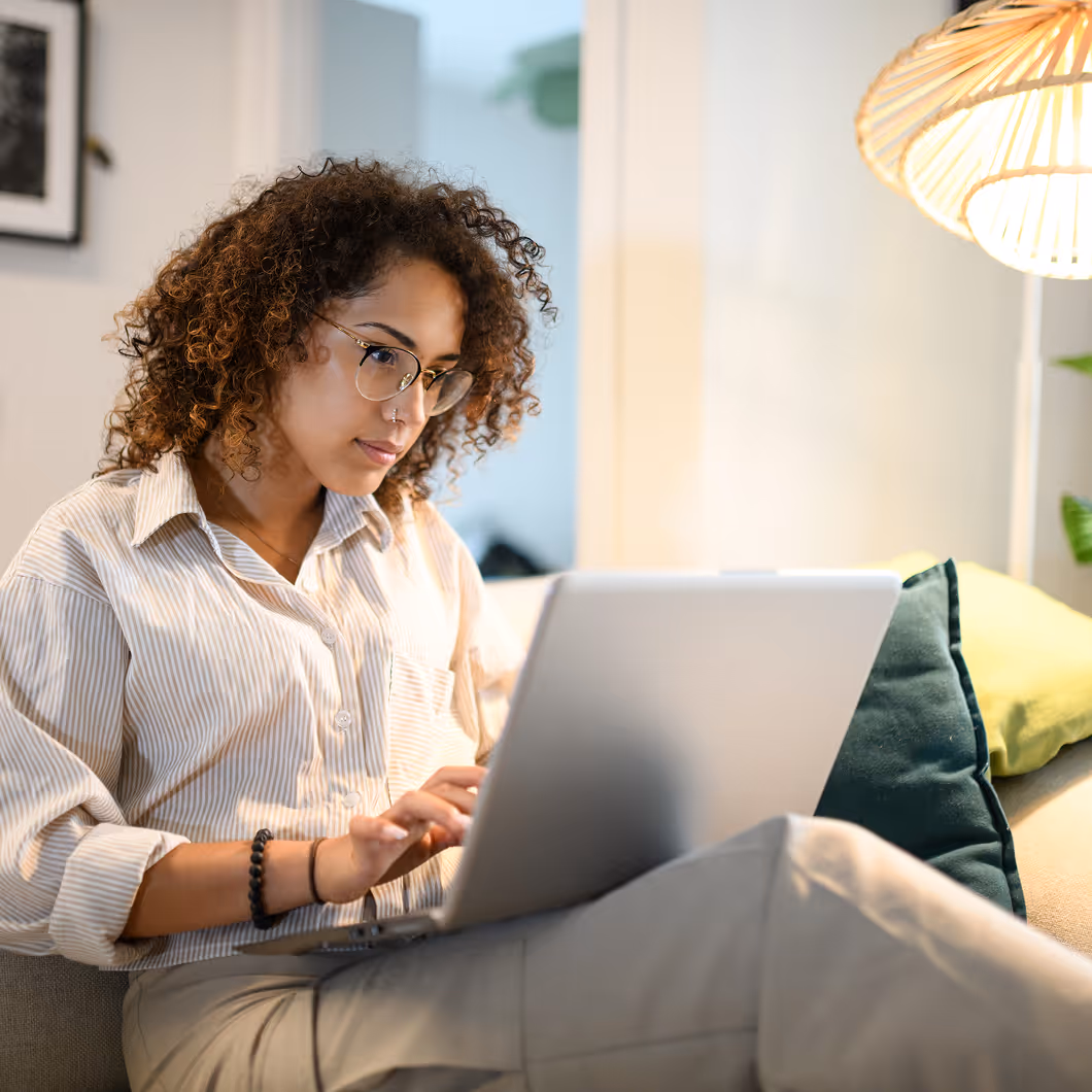 Eine Frau arbeitet im Home Office und chattet mit dem Mitarbeiter-Chatbot von Haufe.