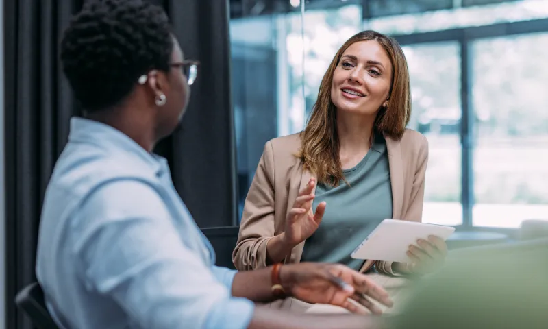 Geschäftsmeeting in moderner Umgebung – Symbolbild für Teamarbeit, Kommunikation und digitale Zusammenarbeit im Unternehmen