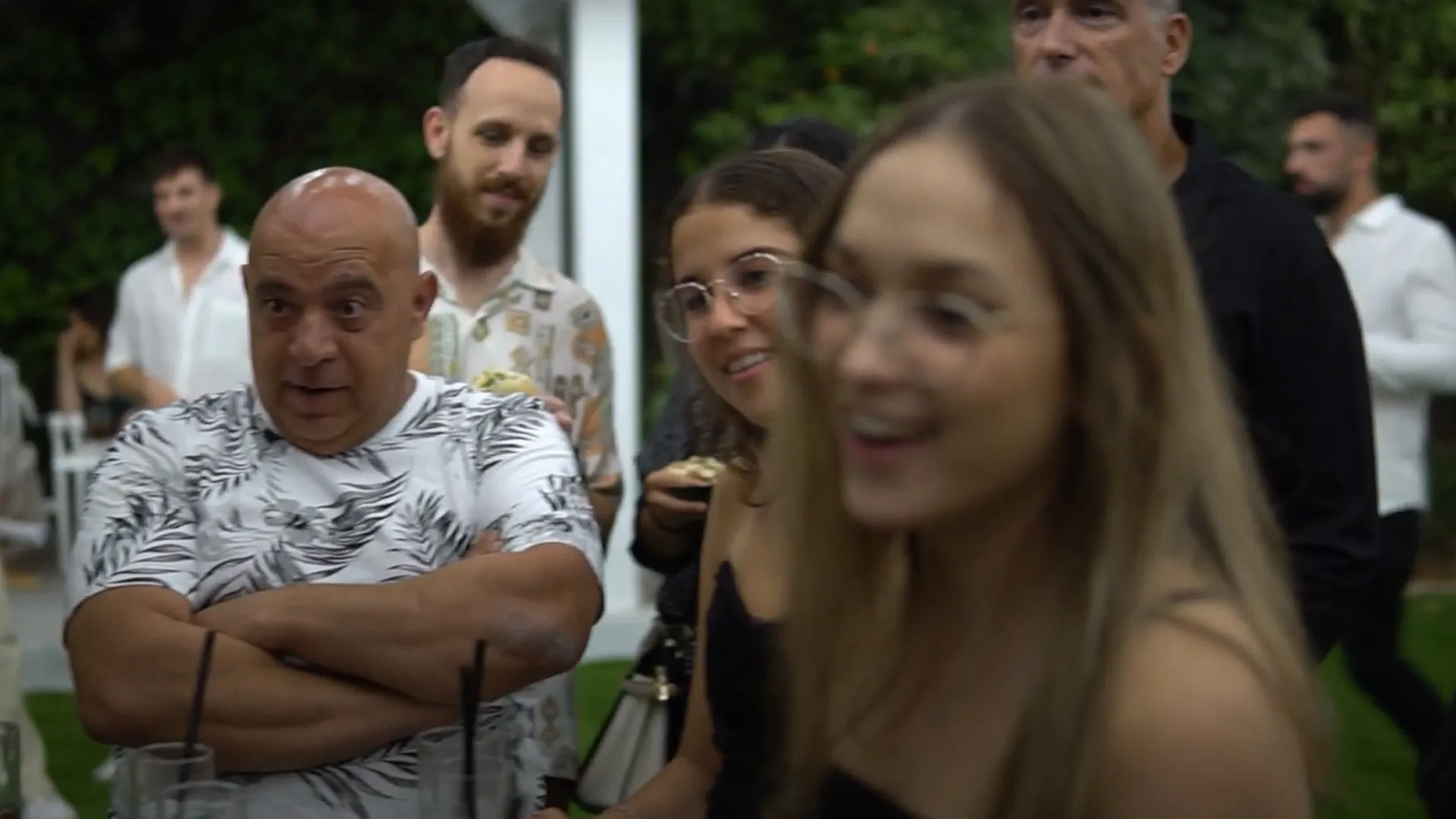 אורחים מחייכים ומרוכזים בביצוע של אמן החושים