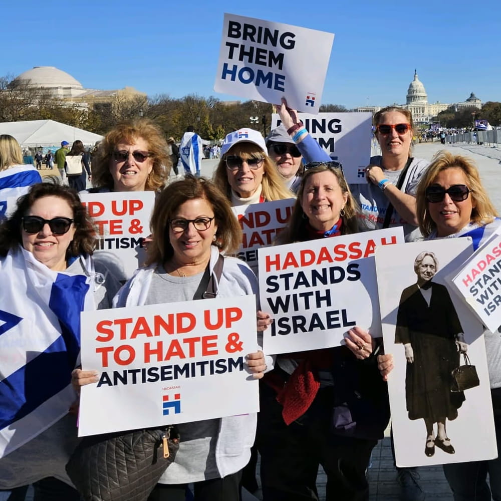A group of people holds signs and Israel flags