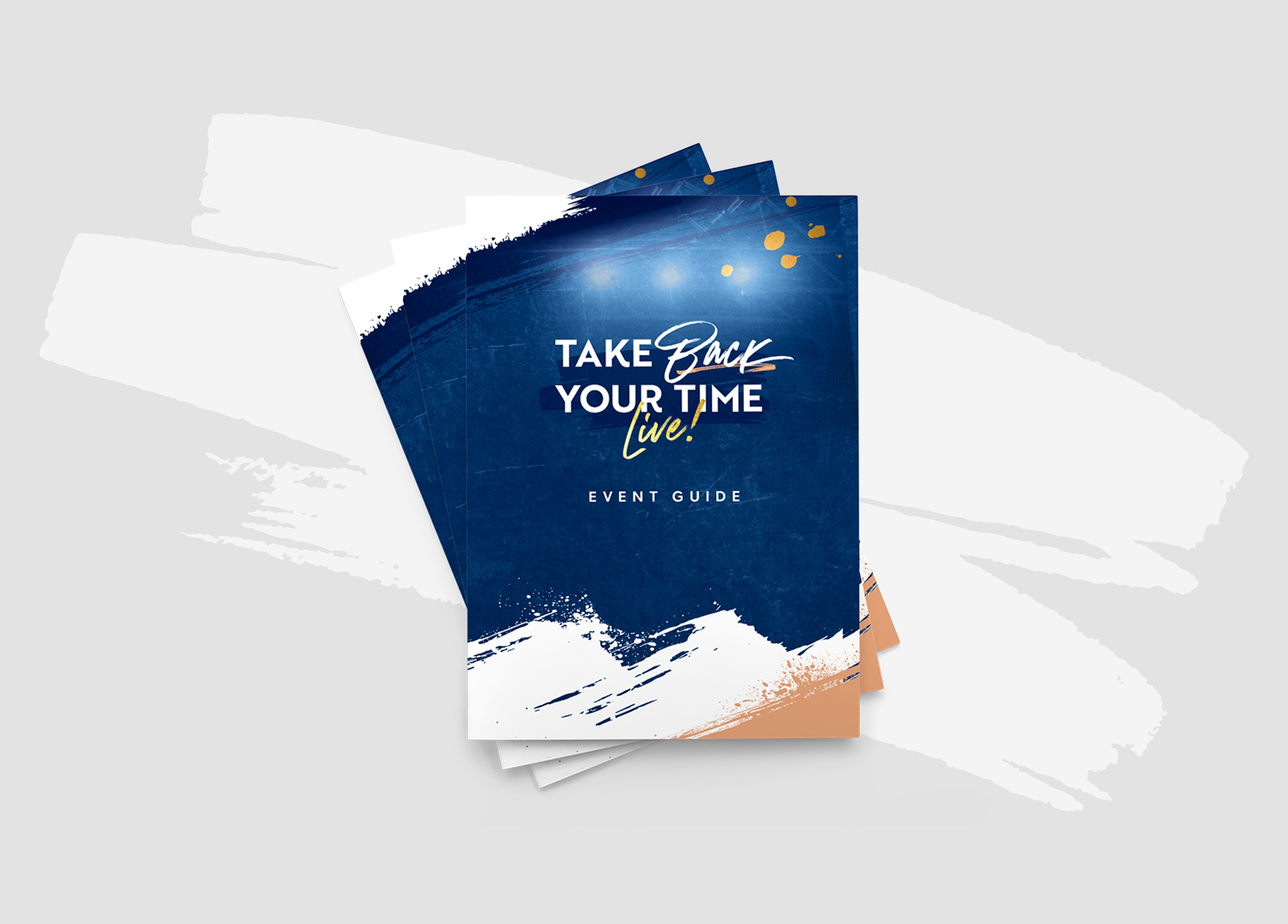 Stack of event guides with a blue, white, and beige painted design titled 'Take Back Your Time Live!'