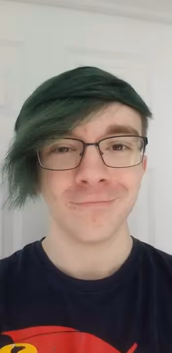 A man with green hair and glasses smiling. - Assistments - Formative Assessment Solutions