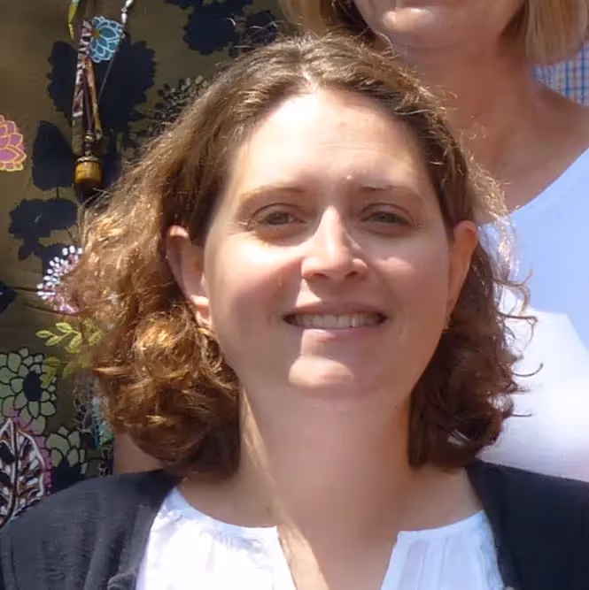 A woman with long hair and a white shirt smiling for the camera. - Assistments - Formative Assessment Solutions