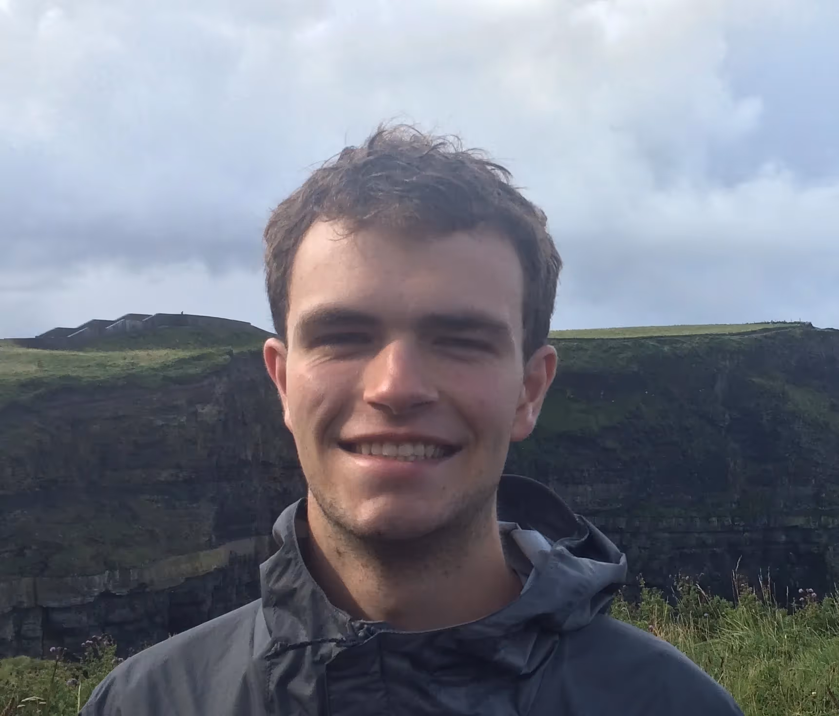 A man wearing a jacket and smiling at the camera. - Assistments - Formative Assessment Solutions