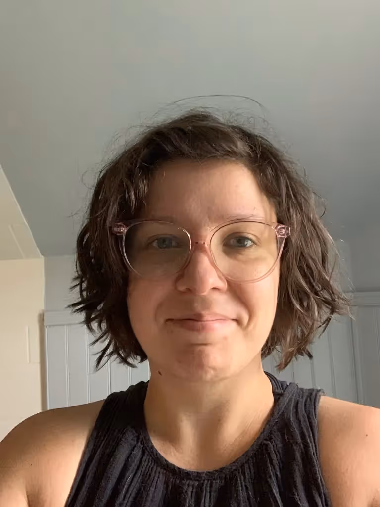 A woman wearing glasses and a black shirt. - Assistments - Formative Assessment Solutions