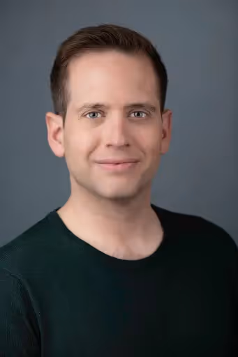 A man wearing a green shirt and smiling. - Assistments - Formative Assessment Solutions