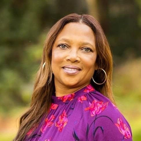 A woman with a purple shirt and a smile. - Assistments - Formative Assessment Solutions