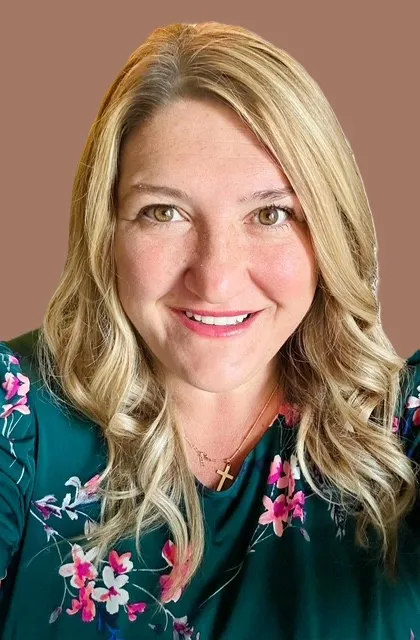 A woman with blonde hair and a green shirt smiling at the camera. - ASSISTments Images