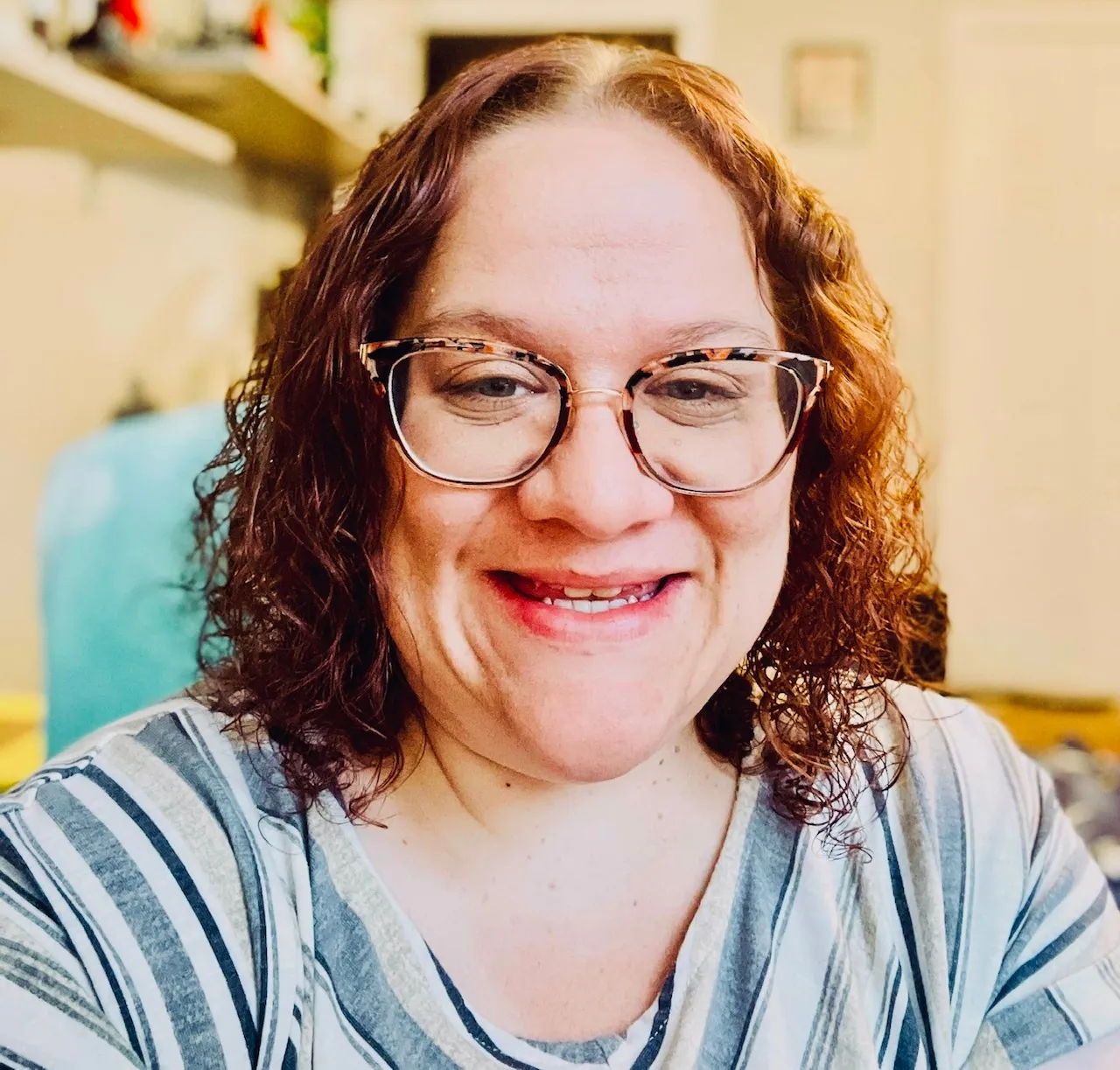 A woman wearing glasses and a striped shirt. - ASSISTments Images