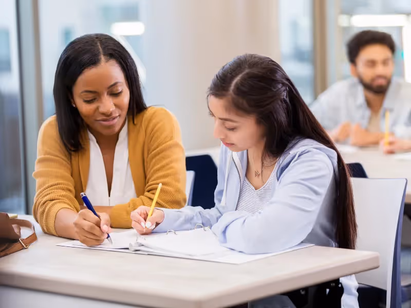 A woman writing on a piece of paper. - ASSISTments Images