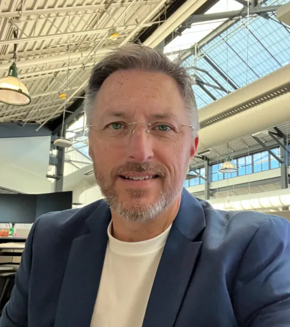 A man wearing glasses and a blue jacket. - ASSISTments Images