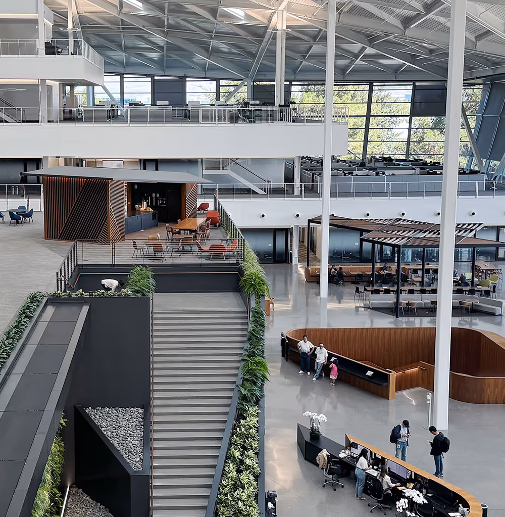 Geräumiges, modernes Büroatrium mit offenen Arbeits- und Besprechungsbereichen.