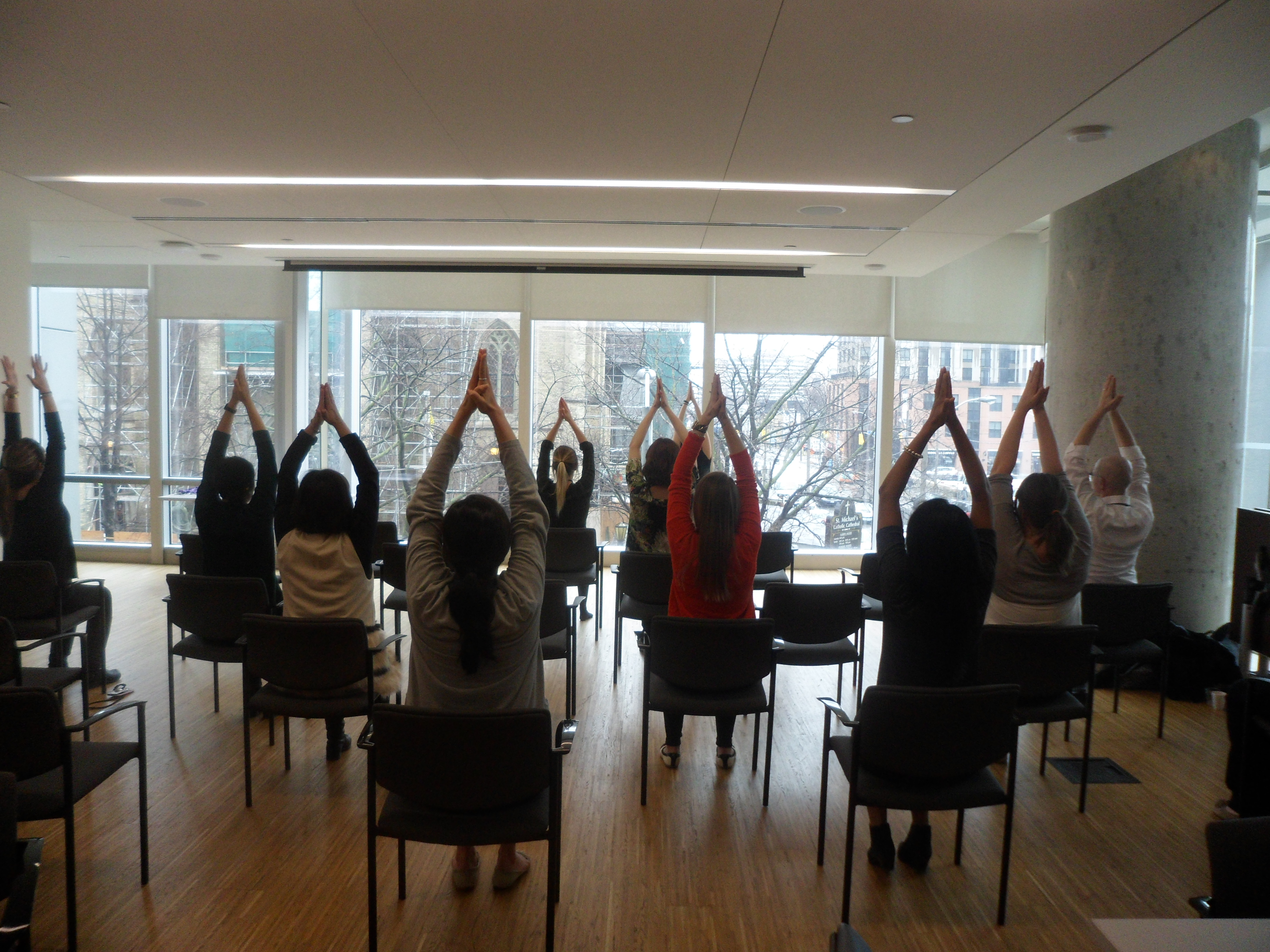 Three Utkata Yoga instructors demonstrating seated shoulder stretches