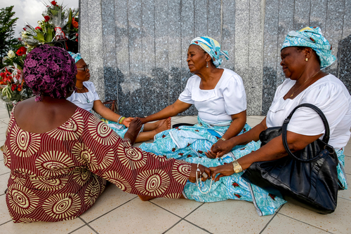 A circle of African women going hands in prayer
