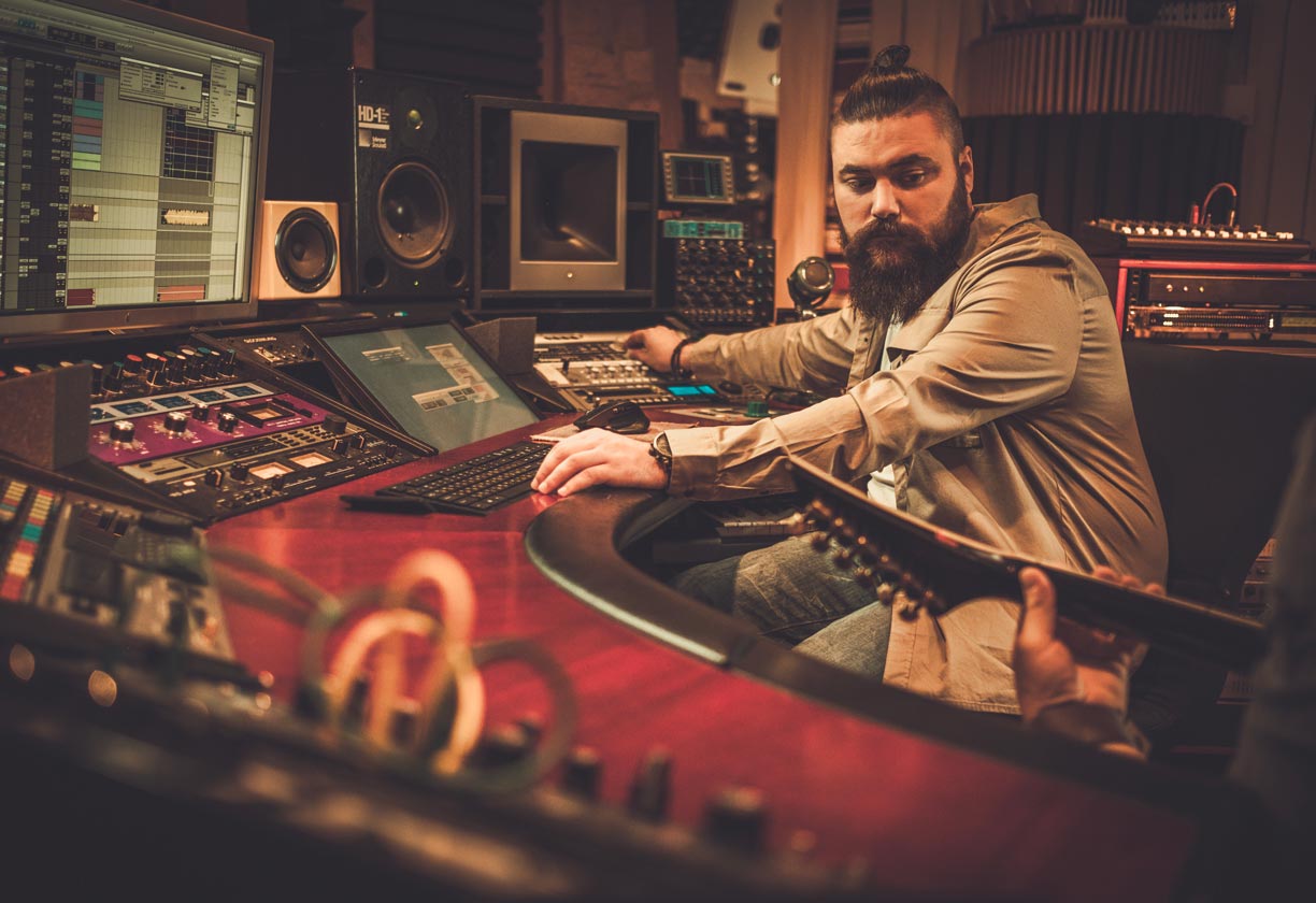A sound engineer capturing the performance of a guitar player.
