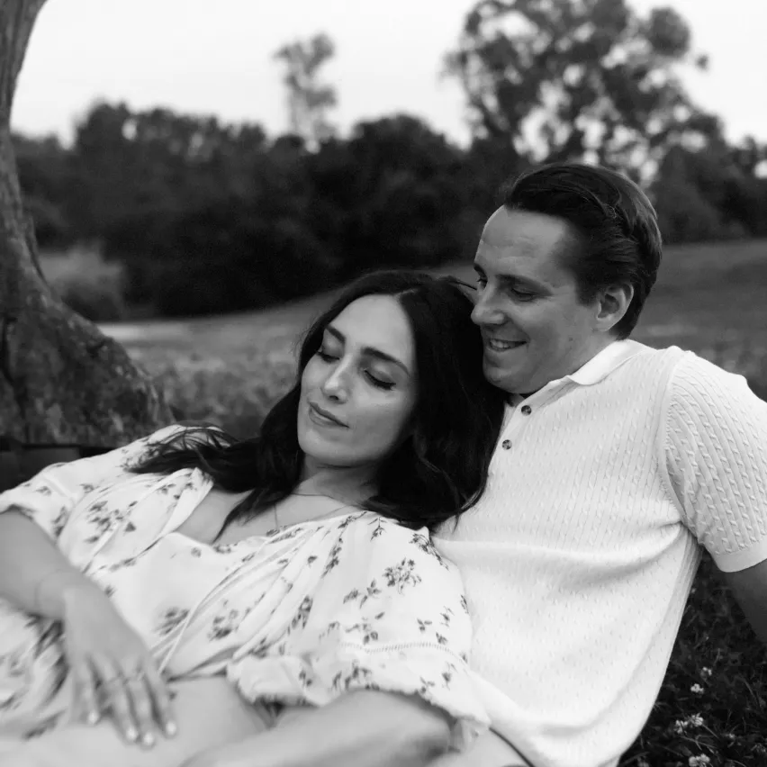 engaged couple laying in grass at the Ottawa Dominion Arboretum photo session